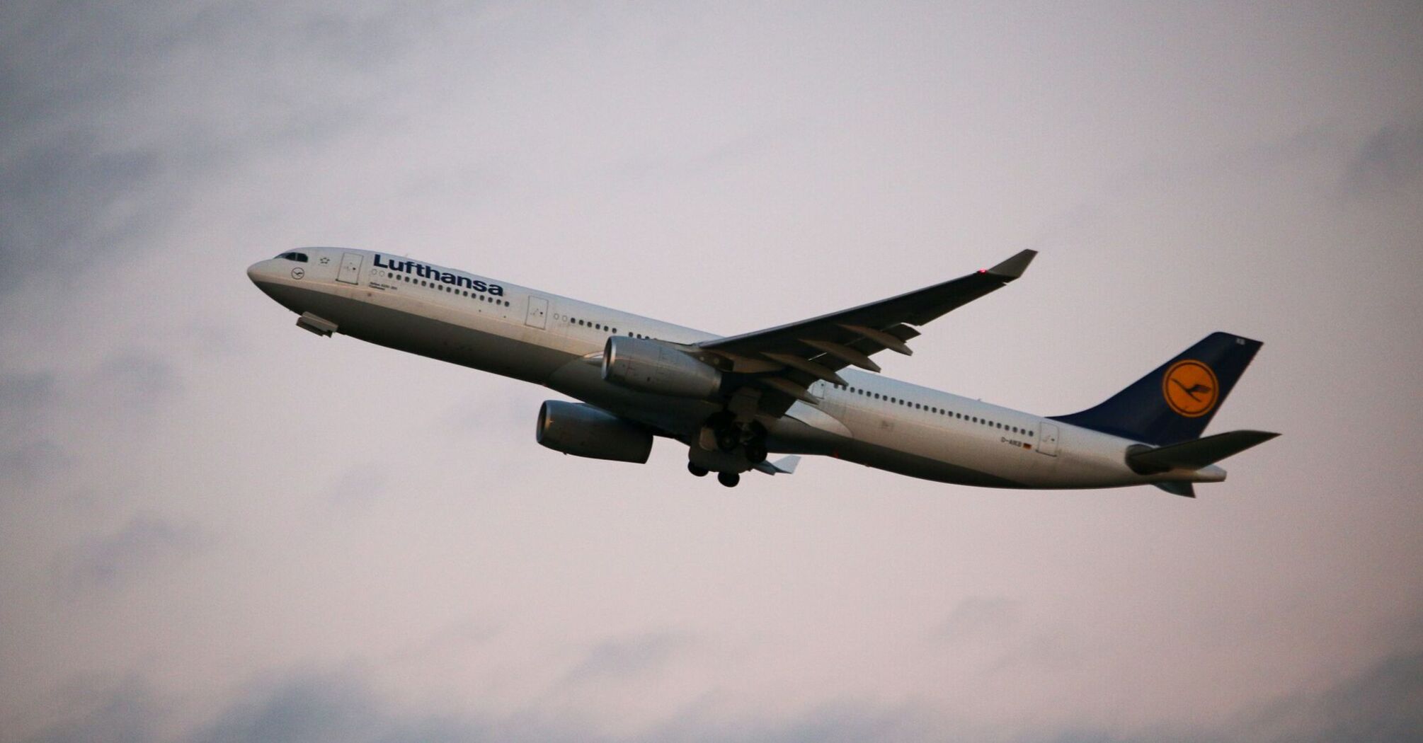 Lufthansa aircraft flying against a serene evening sky