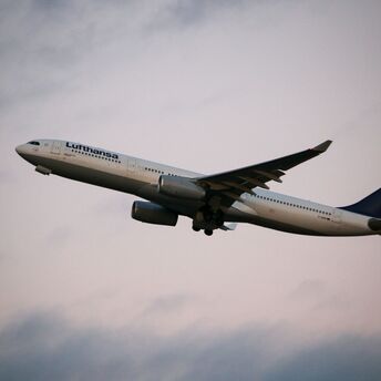 Lufthansa aircraft flying against a serene evening sky