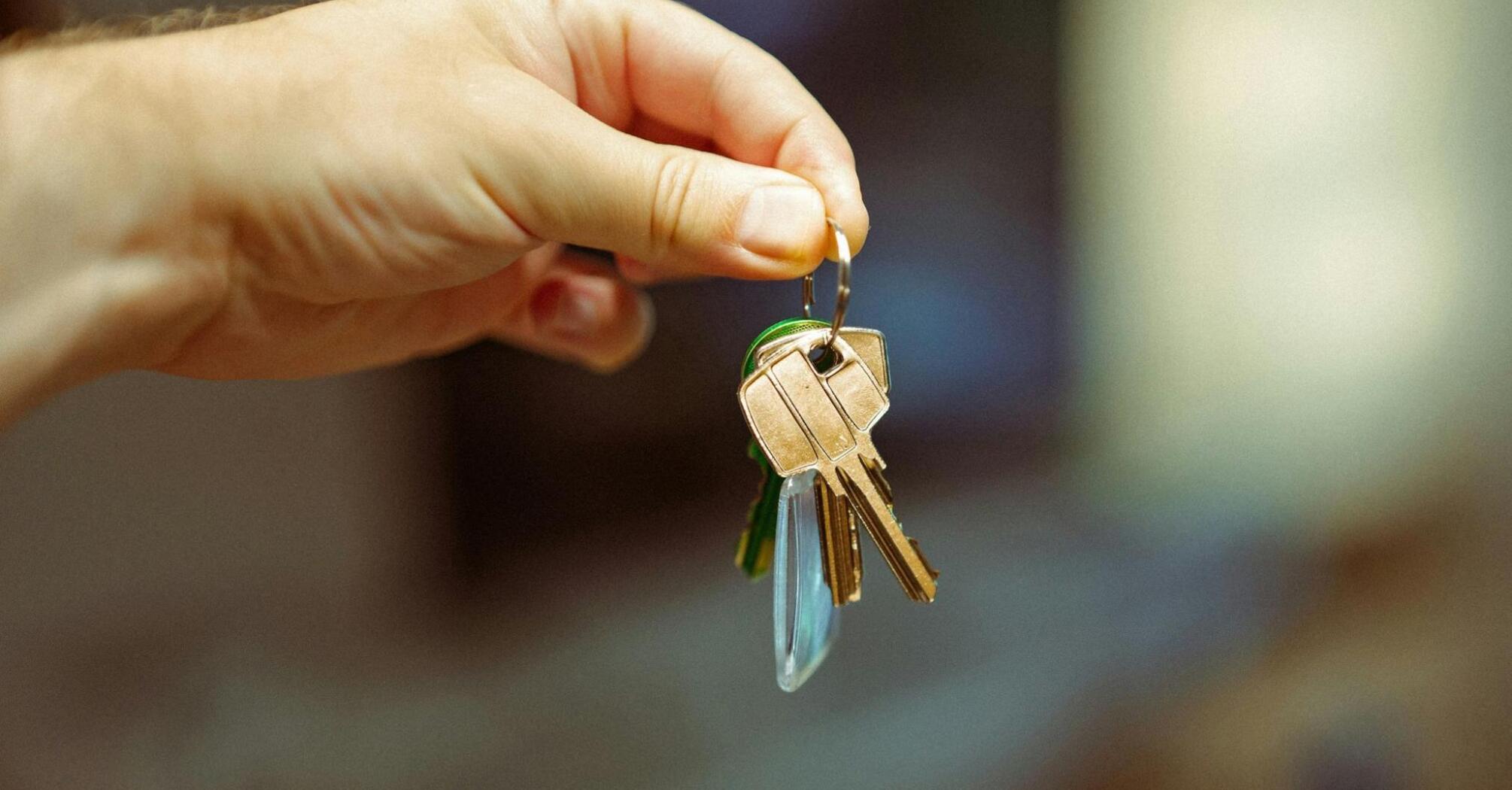 A hand holding a set of keys, symbolizing access and property ownership