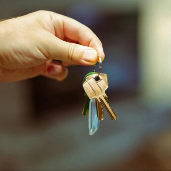 A hand holding a set of keys, symbolizing access and property ownership