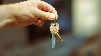 A hand holding a set of keys, symbolizing access and property ownership