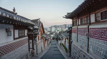 Traditional Korean hanok village with modern Seoul skyline in the background