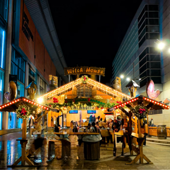 Festive Christmas market stall illuminated at night in Manchester city center