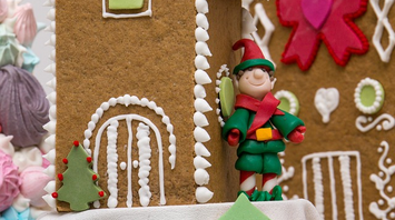 Decorated gingerbread cookie with an elf figurine