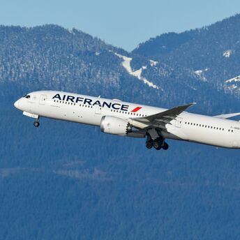 Air France aircraft taking off with mountains in the background