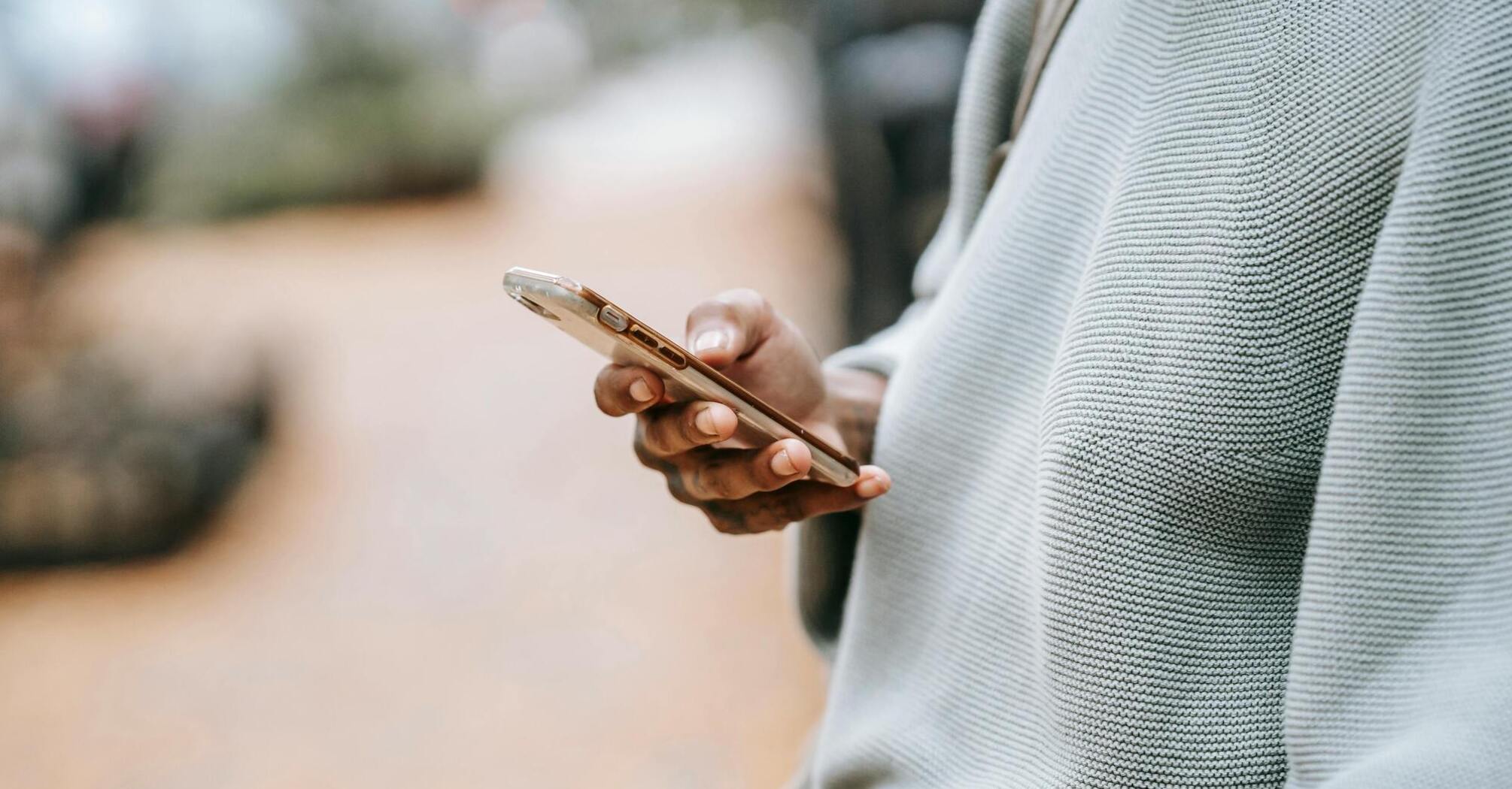 Person holding a smartphone outdoors