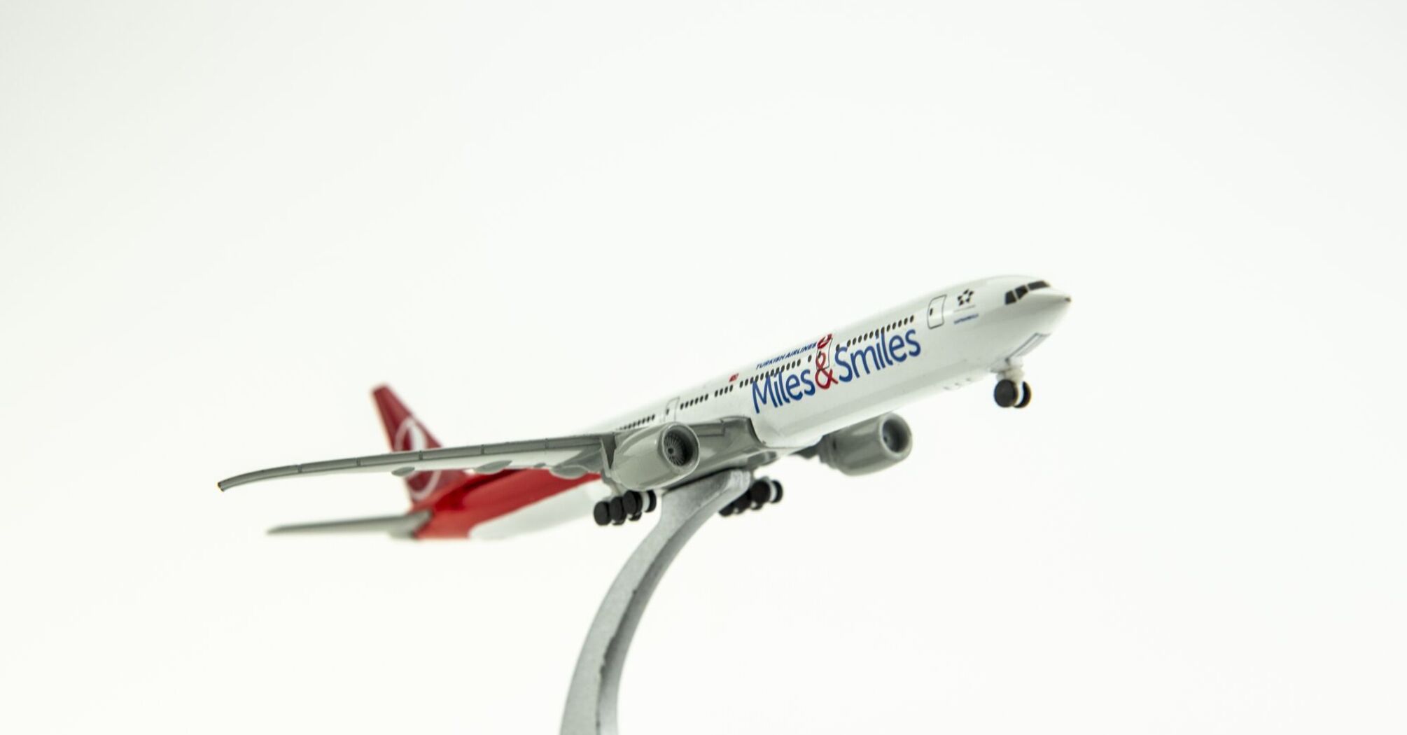 Turkish Airlines airplane model with 'Miles&Smiles' lettering taking off against a white studio background