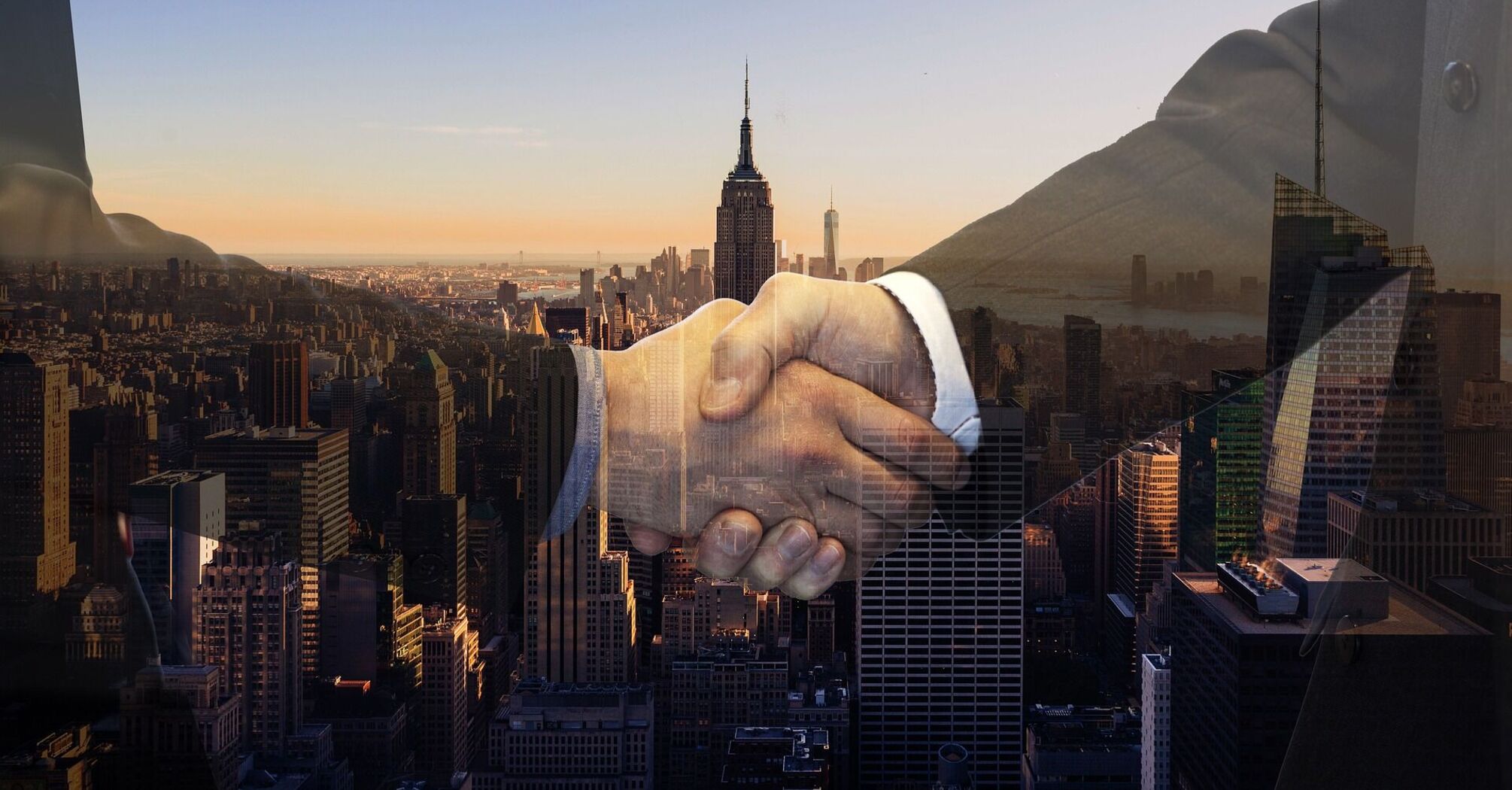 Handshake superimposed on a cityscape backdrop, symbolizing a business partnership
