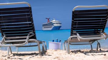 Relaxation loungers overlooking the huge cruise ship Carnival