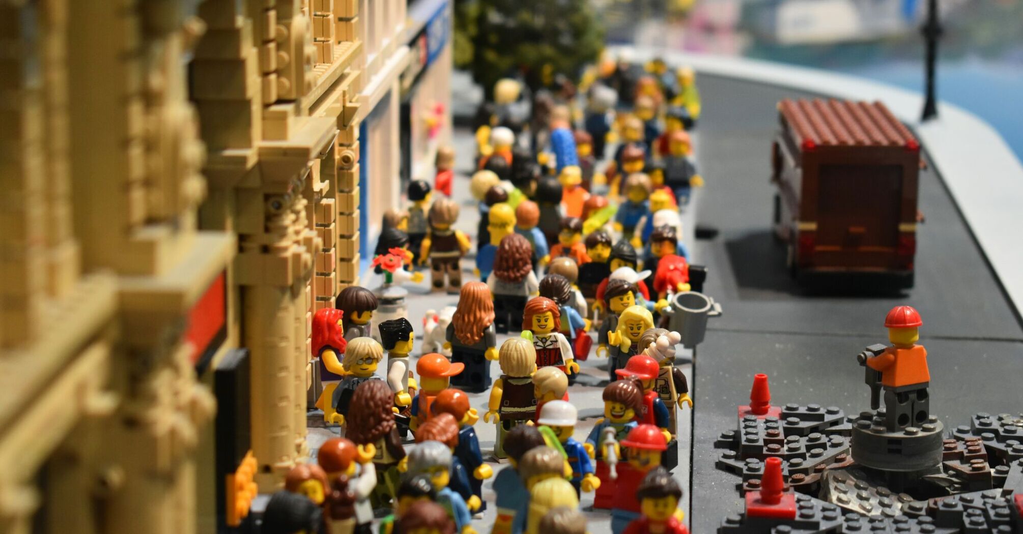 A vibrant LEGO scene depicting numerous LEGO minifigures bustling through a city street