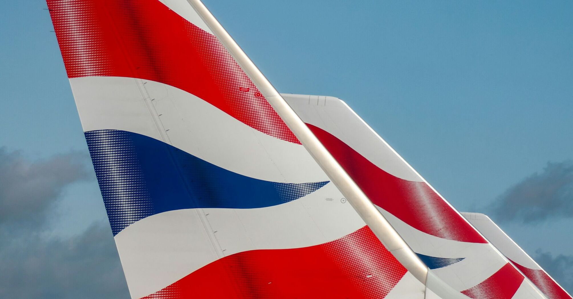 Close-up view of the tail fins of British Airways aircraft displaying the iconic red, white, and blue Union Jack design