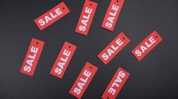 Red 'SALE' tags scattered on a dark background