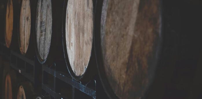Stacked wooden barrels in a dark cellar