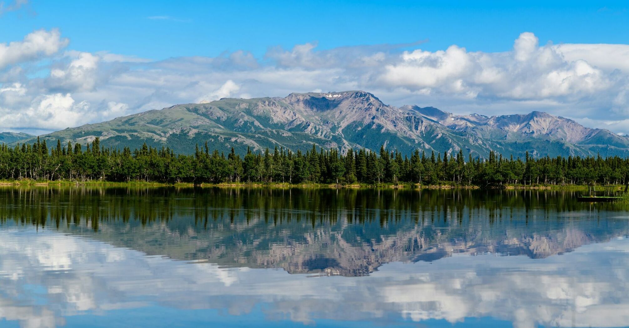 Alaskan mountains reflected in lake's water