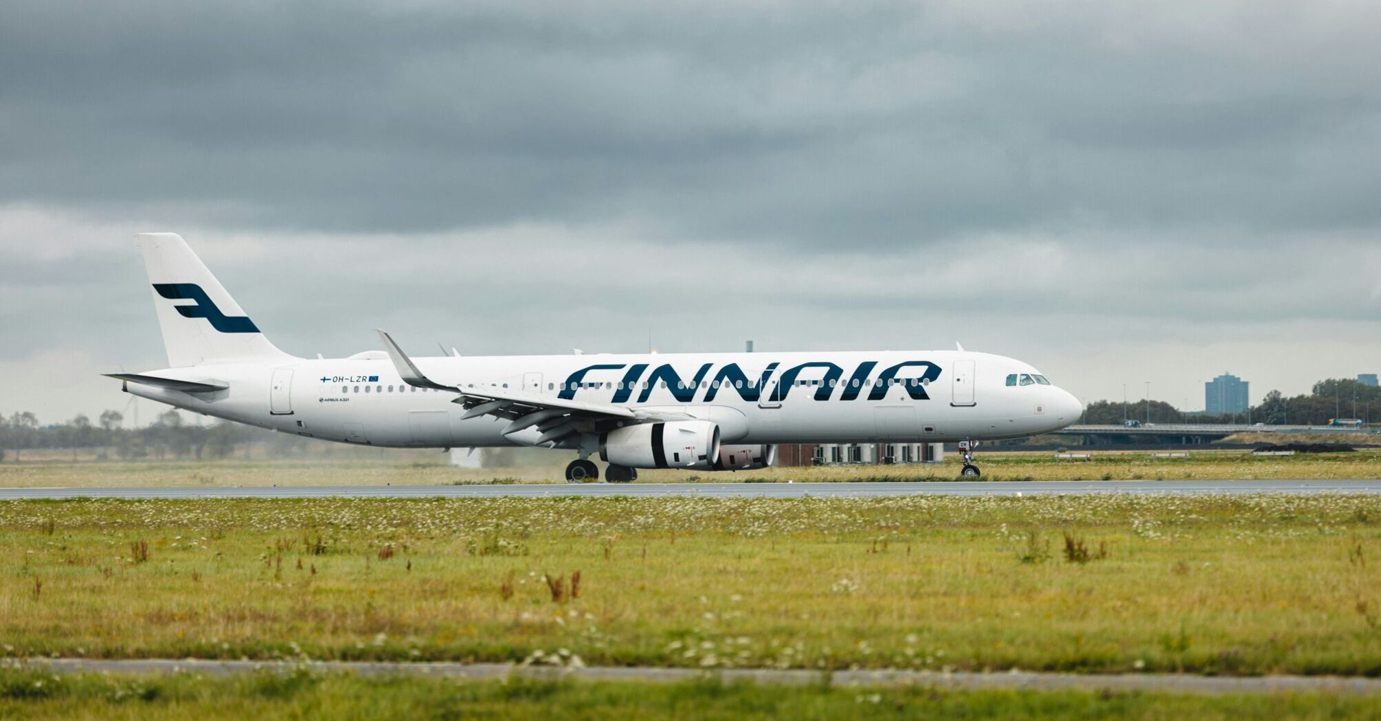 Finnair plane landing and taxiing on a rainy day at the Polderbaan