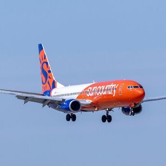 Sun Country Airlines plane flying in the sky