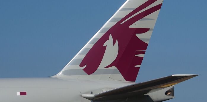 Close-up view of the tail fin of a Qatar Airways aircraft displaying the company logo