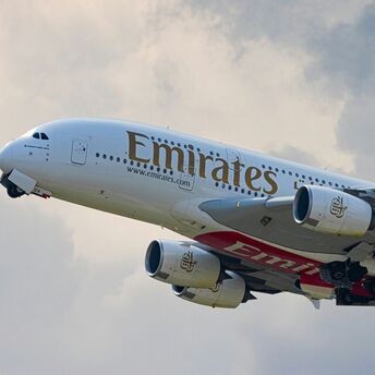 Emirates white and red passenger plane in the sky