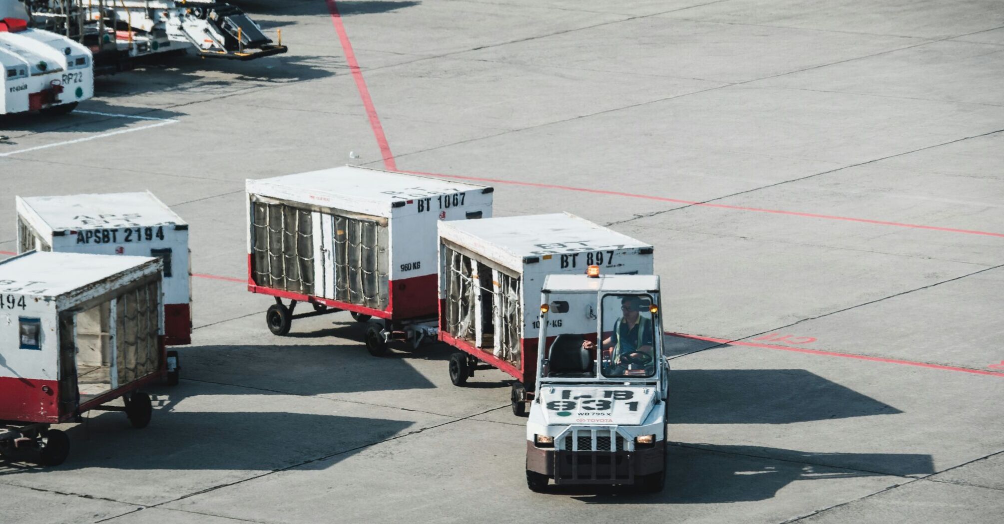 Two white and red baggage trucks
