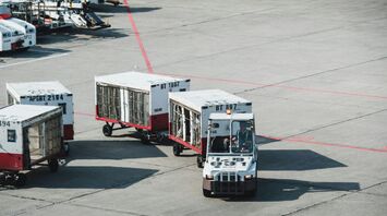 Two white and red baggage trucks