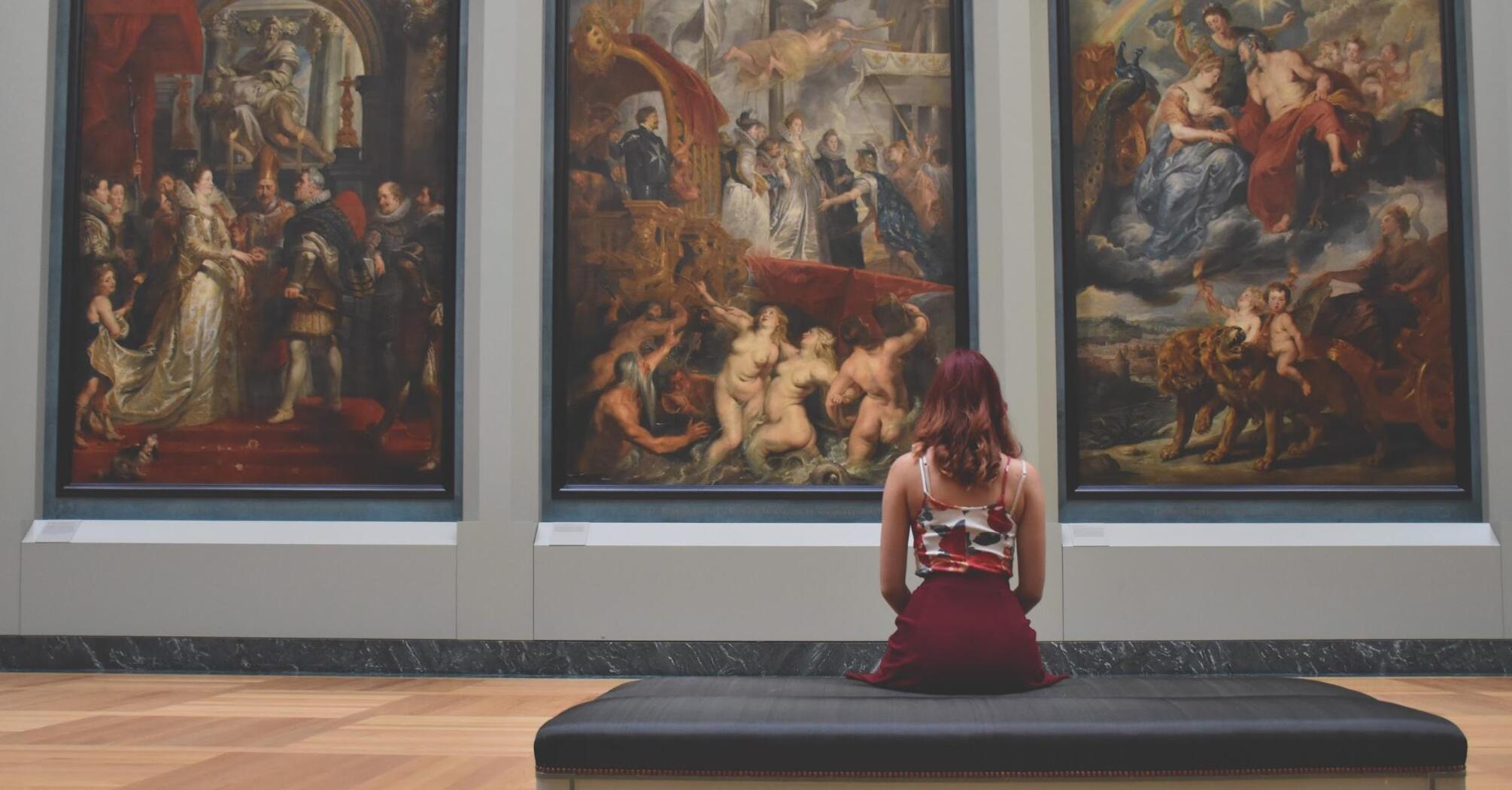 Girl looking at paintings by great artists 