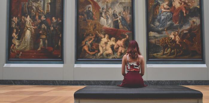 Girl looking at paintings by great artists 