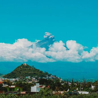 Buildings, trees and Popocatepetl volcano during day