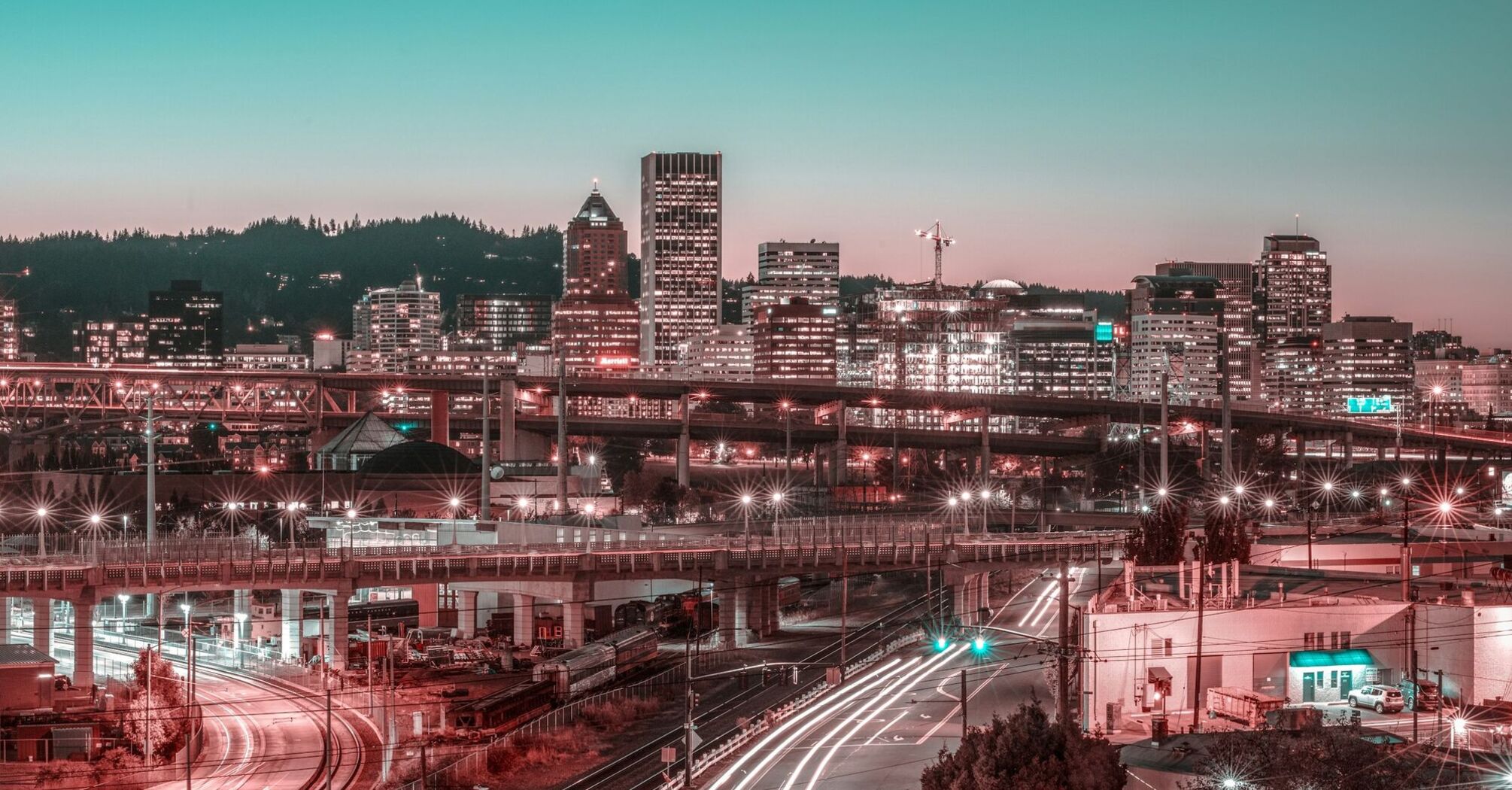 Twilight cityscape with illuminated buildings and bustling traffic trails in Portland, Oregon