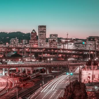 Twilight cityscape with illuminated buildings and bustling traffic trails in Portland, Oregon