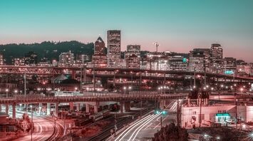 Twilight cityscape with illuminated buildings and bustling traffic trails in Portland, Oregon