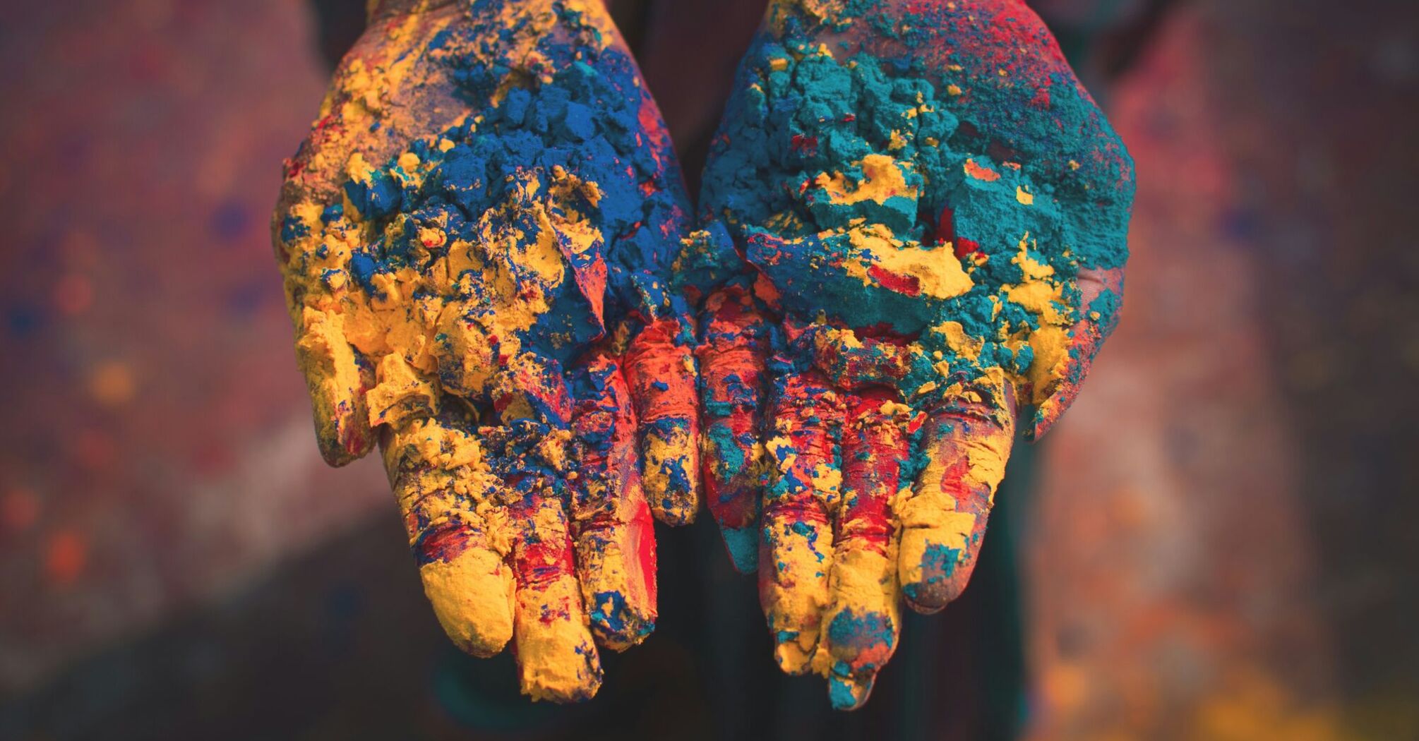 Colorful powdered hands during Holi festival, symbolizing India's vibrant culture
