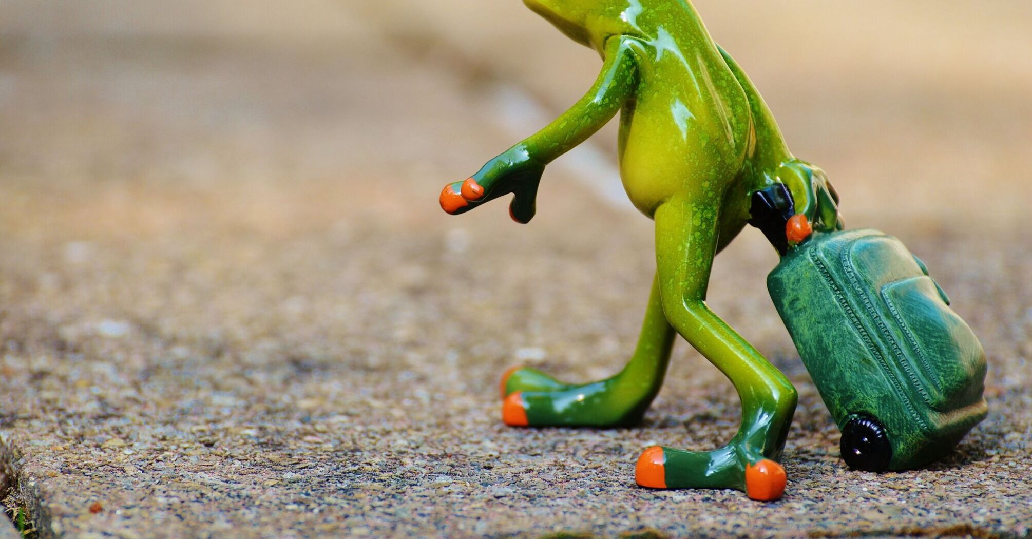 A colorful figurine of a frog standing upright and walking, carrying a green backpack