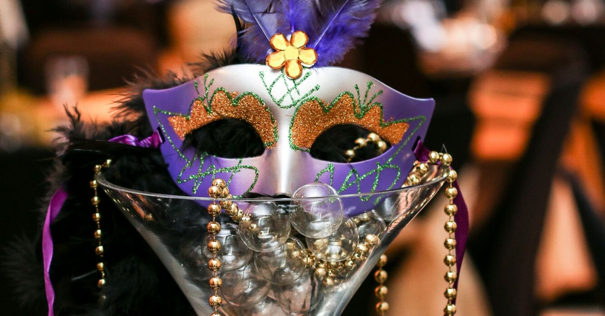 A decorative Mardi Gras mask and beads, evoking the festive spirit of SeaWorld Orlando's Mardi Gras celebration