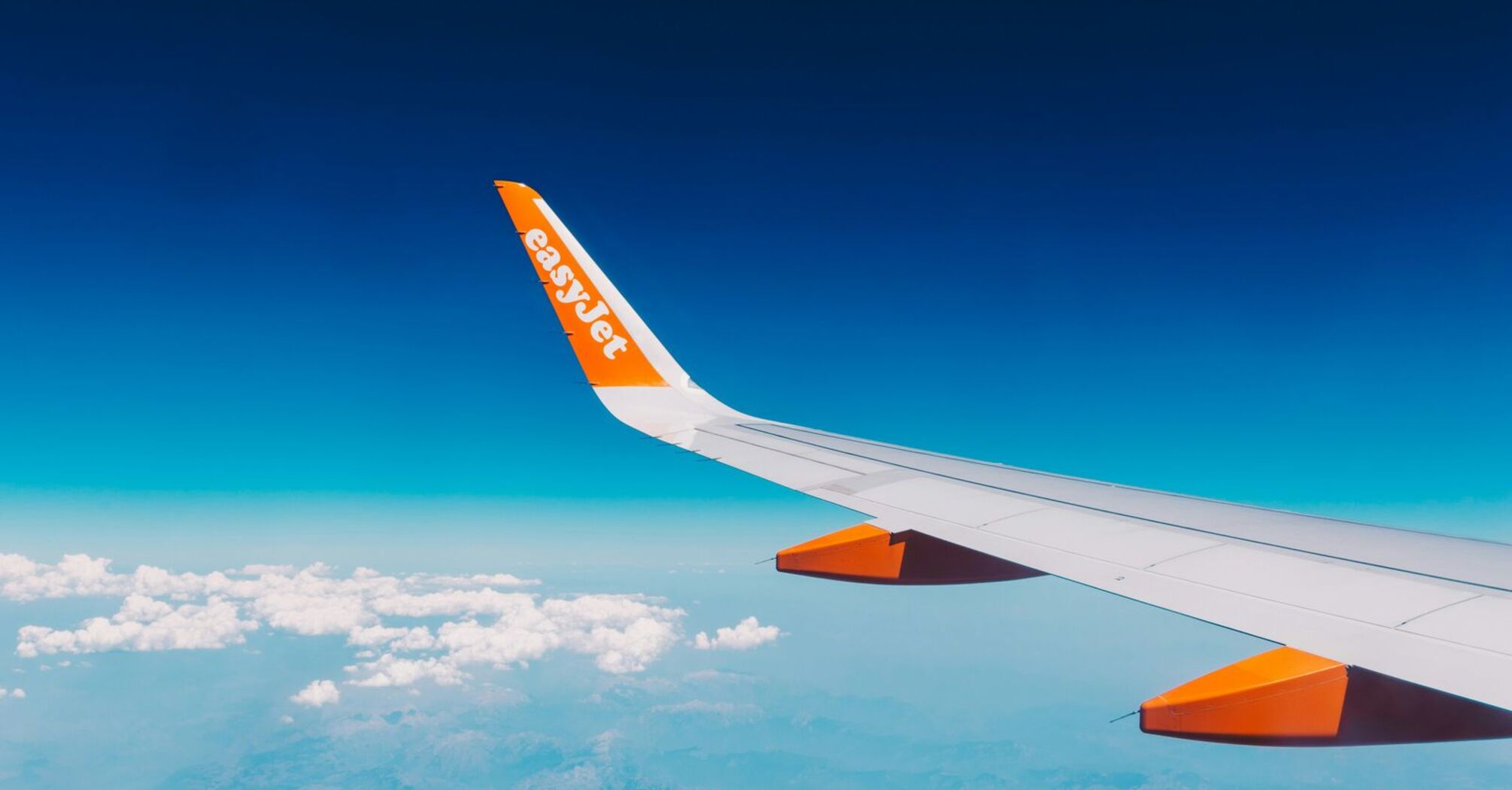 Wing of an easyJet plane against a clear sky