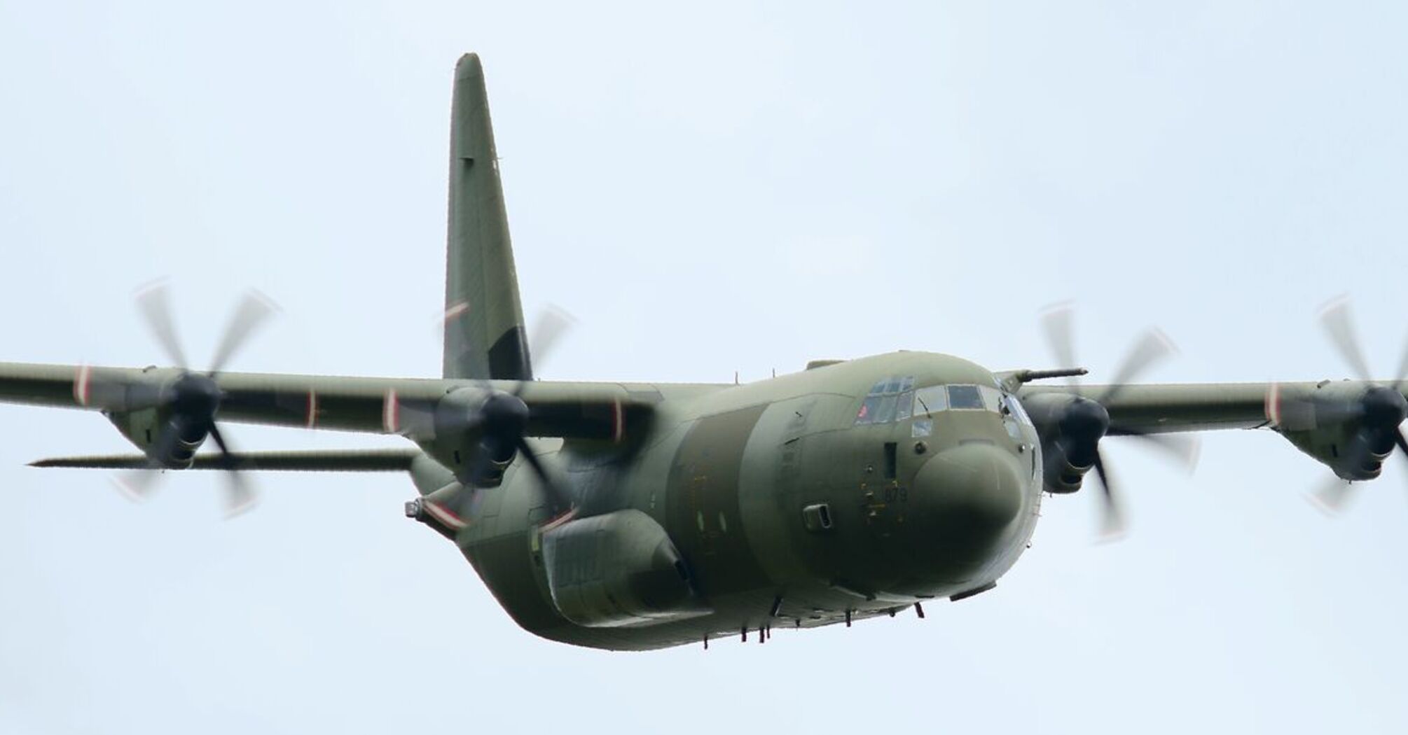 C-130 military transport aircraft in flight against a clear sky