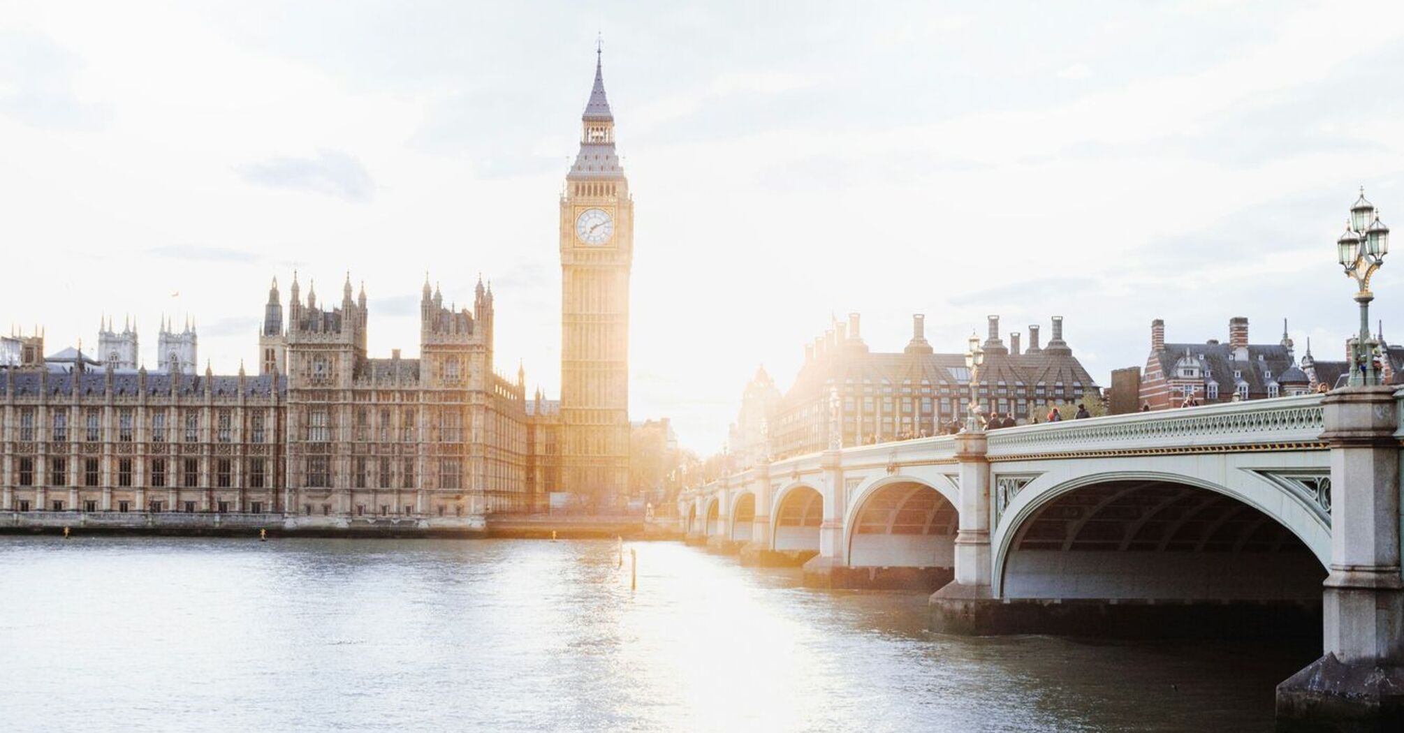 Sunlit view of the Big Ben and Westminster Bridge over the Thames River in London