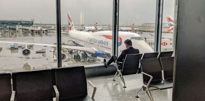 Man in blue shirt sitting on black chair in the London airport