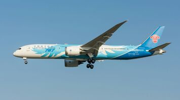 White and blue air plane in mid air during daytime