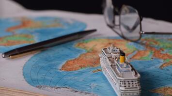 Small toy boat on the background of a world map
