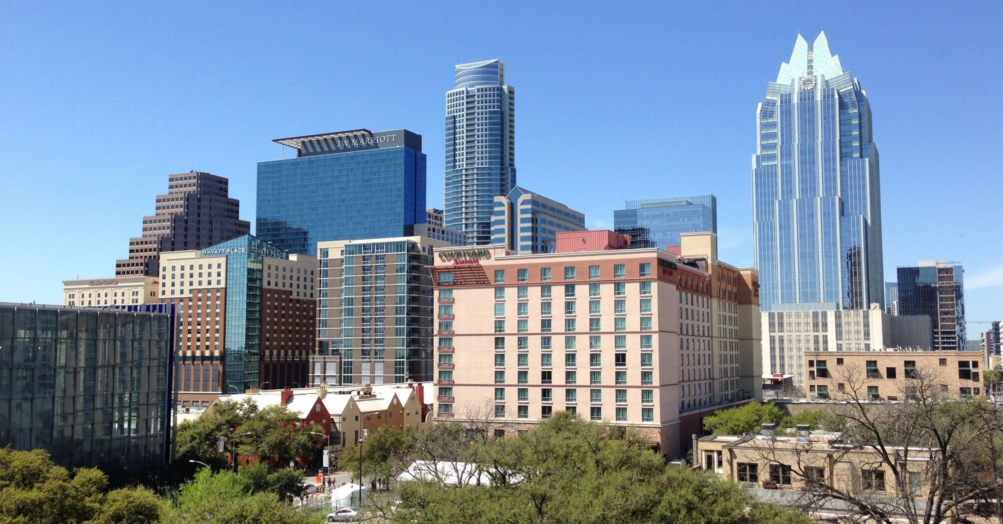 A view of downtown Austin, Texas, showcasing a mix of modern high-rise buildings and traditional architecture under a clear blue sky
