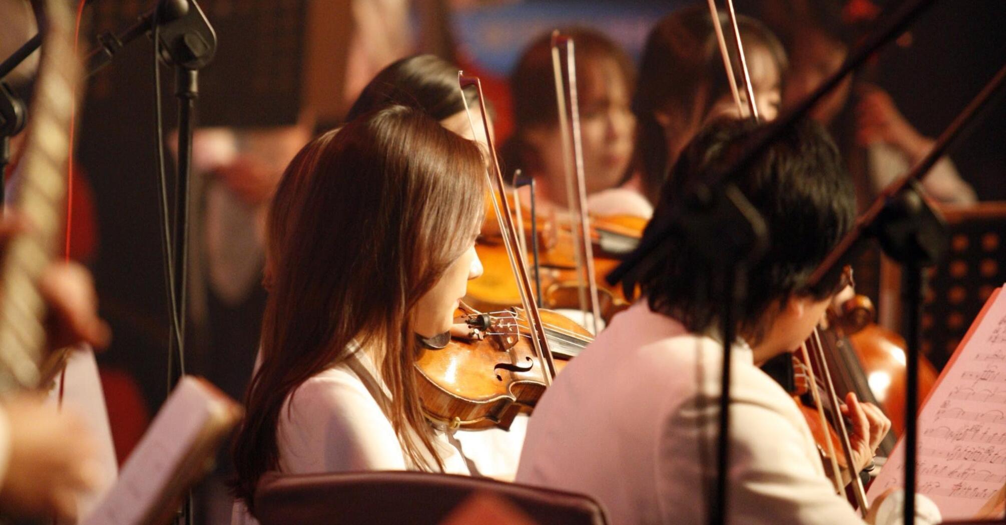 Woman plays the violin in the orchestra