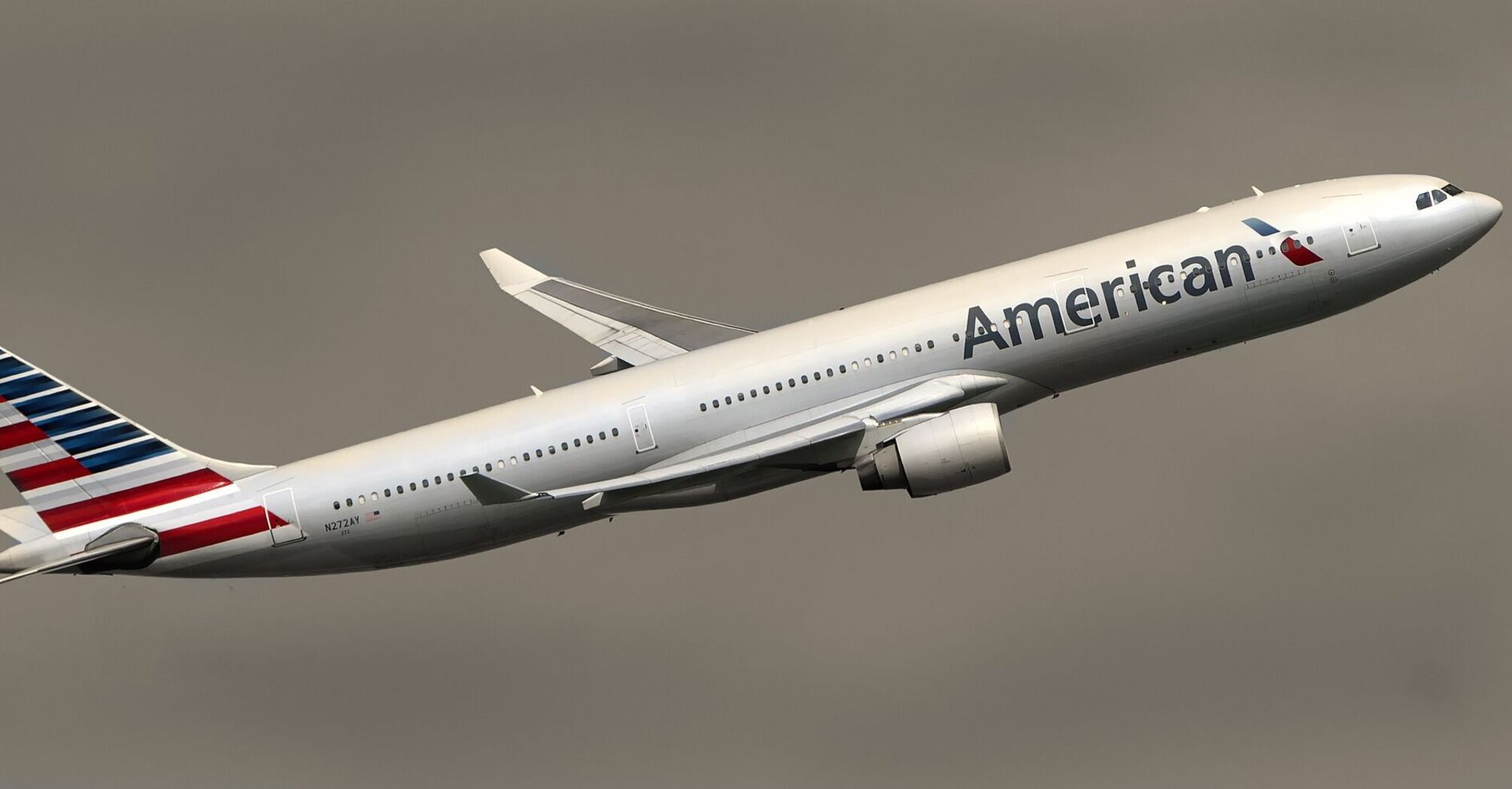 American Airlines Boeing 777 in flight, displaying the company's livery with the American flag on the tail 
