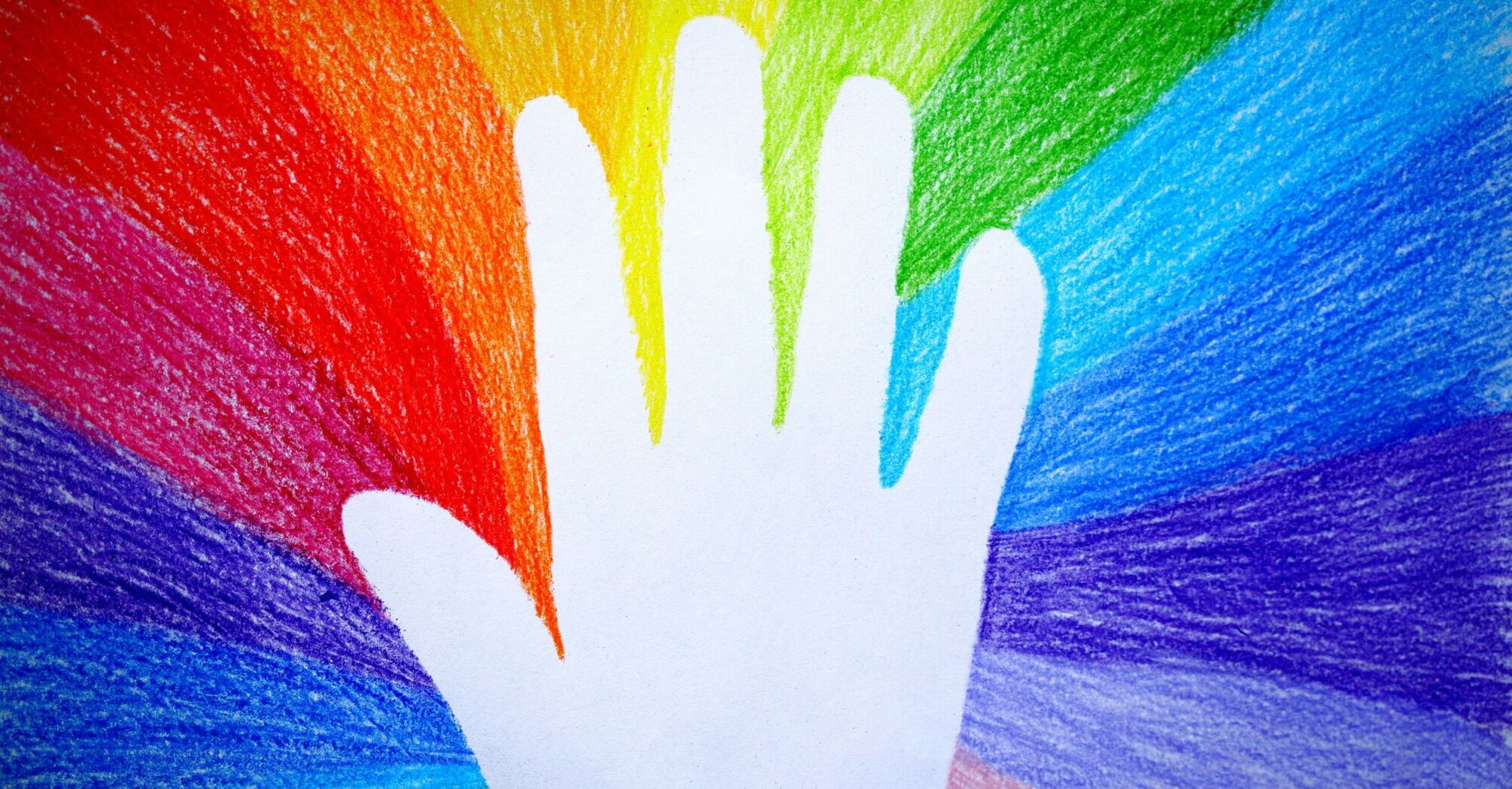 A white handprint centered on a background with radiating rainbow-colored crayon streaks