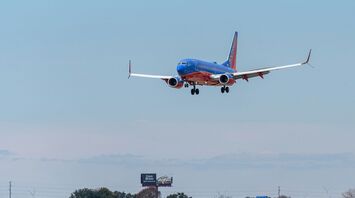 Blue and white passenger plane flying during daytime