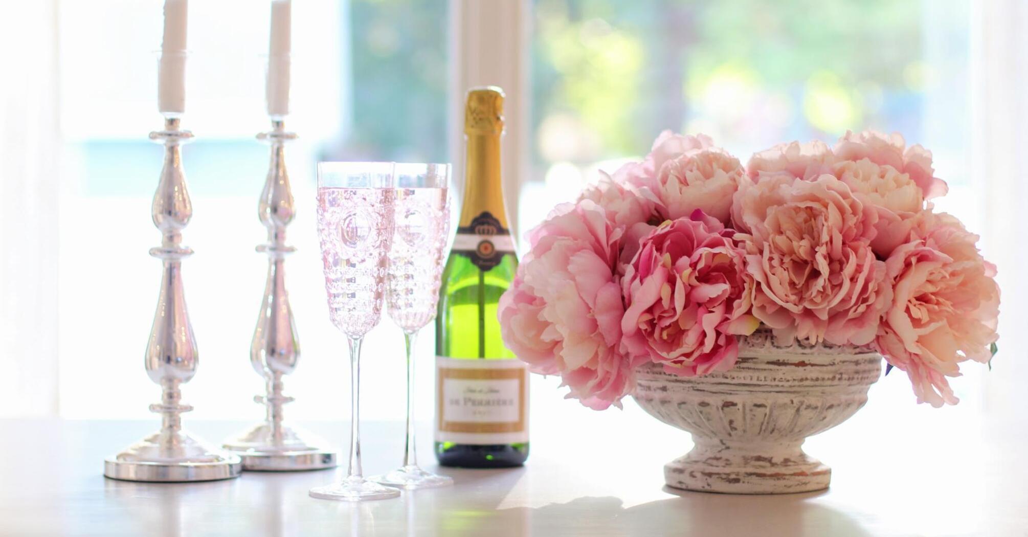 Bottle of champagne with pink spring flowers 