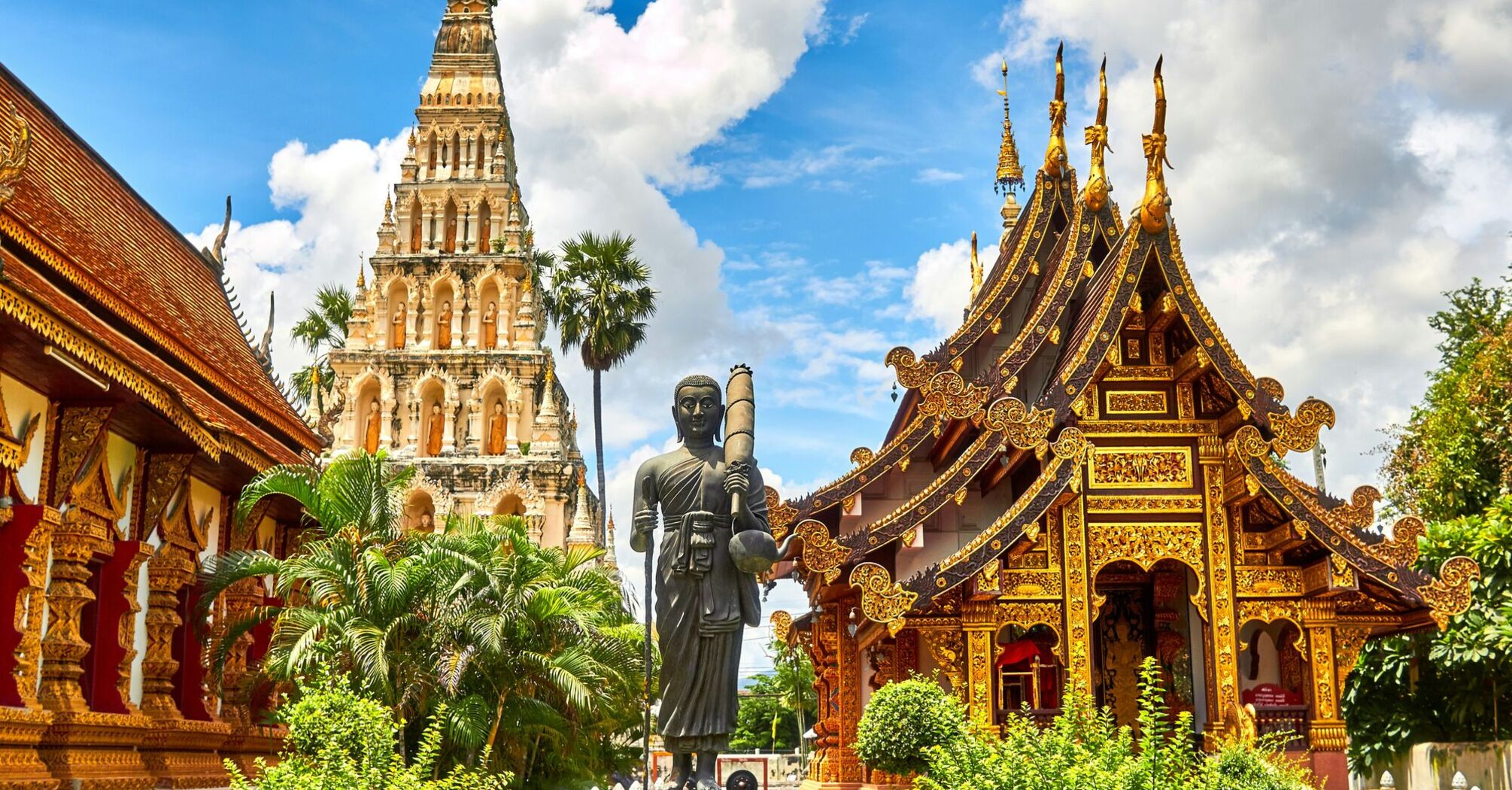 Traditional Thai temple with intricate golden decorations under blue sky