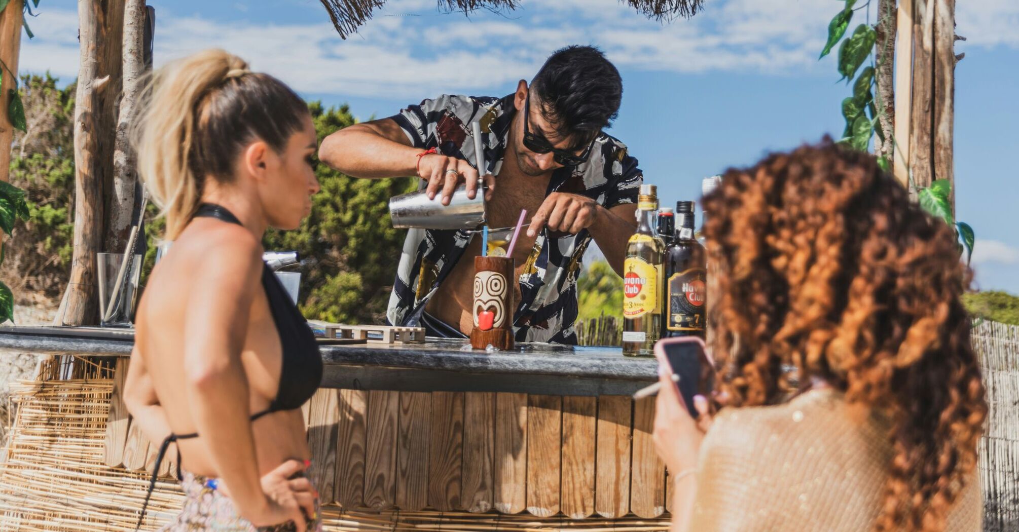 Bartender mixing a tropical cocktail at a beach club party