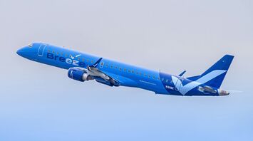 A large blue airplane flying through a blue sky