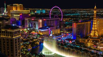 Nighttime view of the Las Vegas with illuminated hotels, the High Roller Ferris wheel, and the Bellagio fountain show
