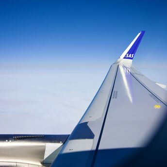 View of the sky from a plane window with the wing and SAS logo visible